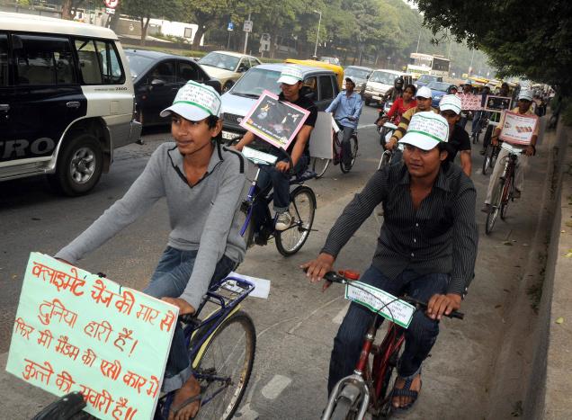 Illustration 3 : défilé cycliste en soutien au BRTS. La pancarte porte un slogan soulignant le rôle des divisions de classe dans le débat : « Alors que le réchauffement climatique frappe la planète, on promène le chien dans la voiture climatisée de Madame » (Source : The Hindu, 2009)