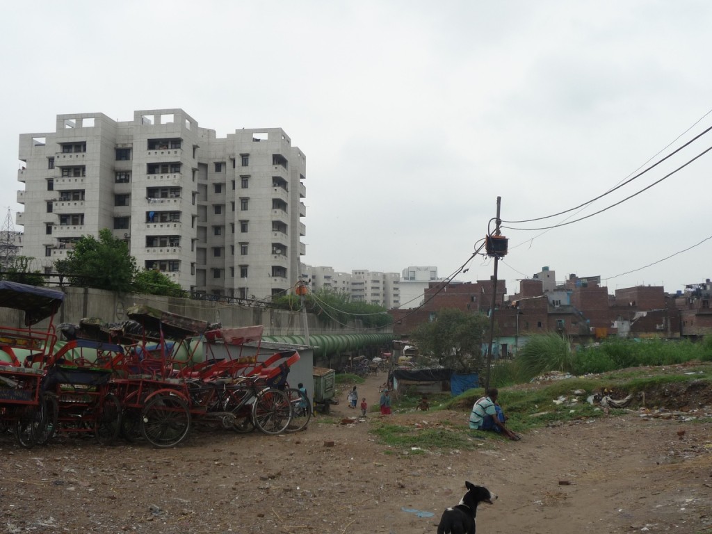 À gauche le projet Shastri Park de la DMRC et à droite les espaces résidentiels réceptacles des impacts directs du grand projet. L'affaissement des terrains provoqué par le grand projet est visible (Bon, 2012)